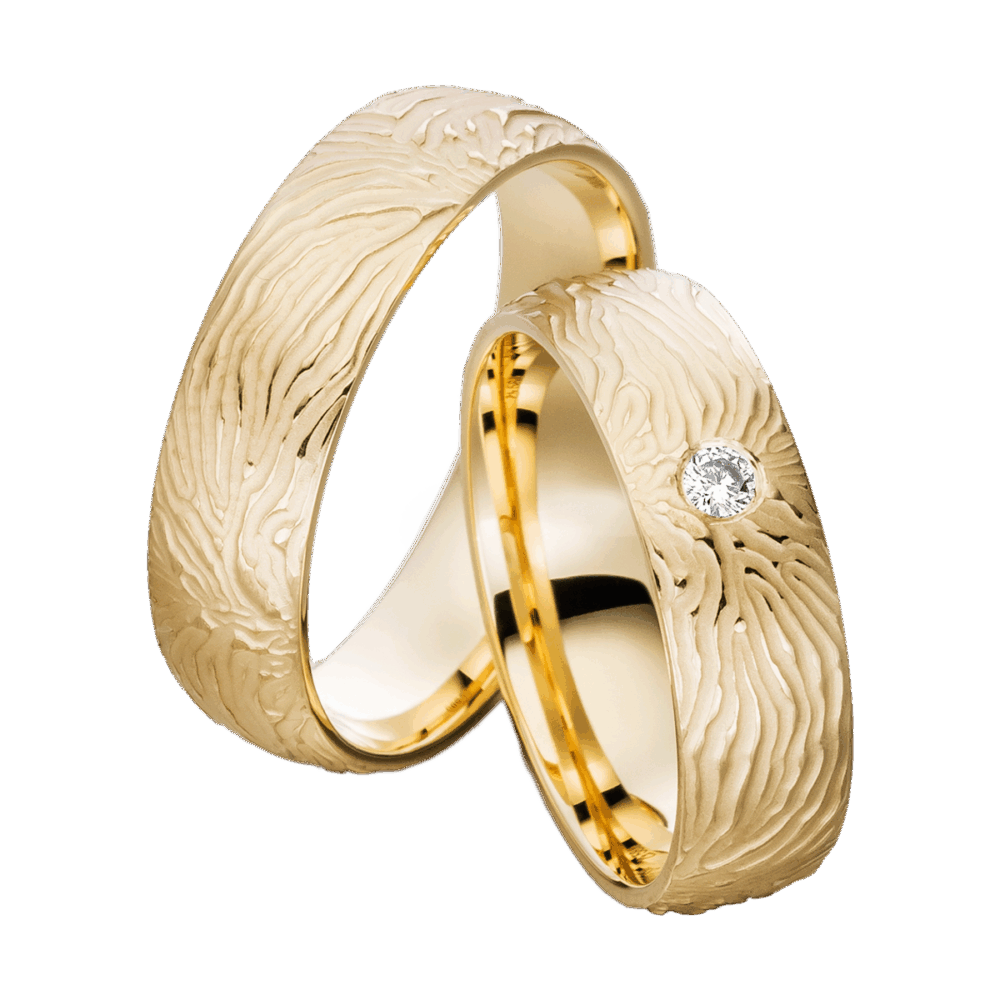 Gelbgoldene Trauringe Sonnenwind mit dynamischem Relief, sandmattem Finish und strahlendem Brillanten