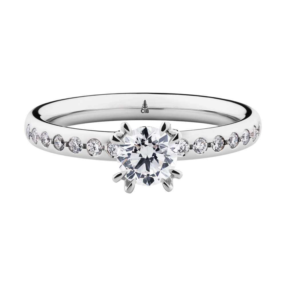 Weißgoldring „Thunder“ mit zentralem Brillant in acht Krappen und seitlichen Diamanten in verjüngter Schiene – ein Klassiker mit moderner Note