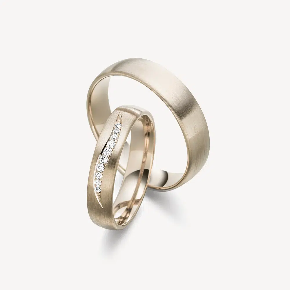 Warm Nights Trauringe von DAVINÉL im Paar: Herrenring in 585/- Chamoisgold mit längsmattierter Oberfläche, Damenring in Chamoisgold mit zehn Brillanten in Wellenformation